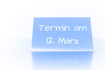 Termin am 12. M&auml;rz - blauer Zettel mit Notiz