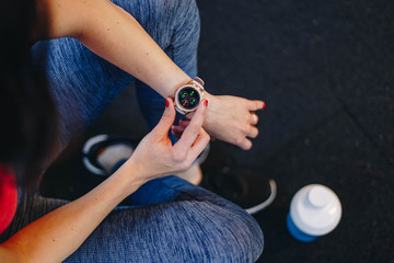 healthy lifestyle concept. fitness woman after workout session checks results on smartwatch in fitness app. detail of female athlete wearing sport tracker wristband arm