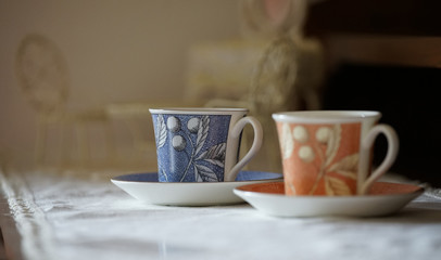 The cup of the drink on the table is orange with blue