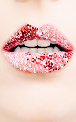 Luxurious bright female lips with red glitter lipstick makeup