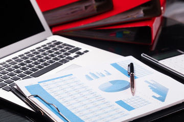 Office workplace with documents and stationery near red folders
