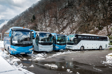 Intercity buses parked near the mountain forest at winter © Dushlik