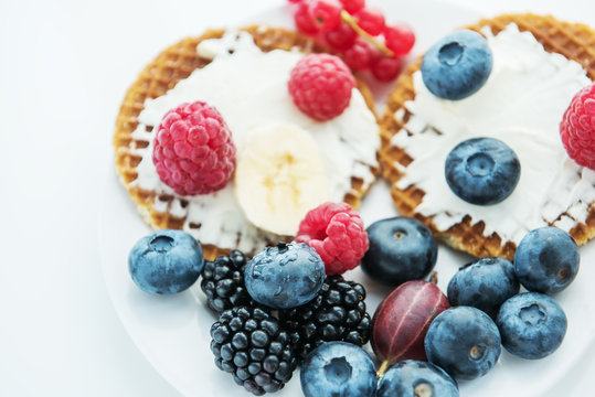 Waffles and various fresh berries and fruits. Healthy tasty breakfast, snack. Very soft selective focus.
