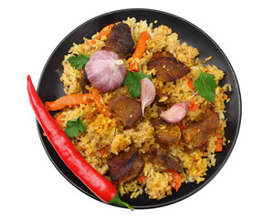 pilaf with meat and chili pepper on black plate isolated on white background. top view