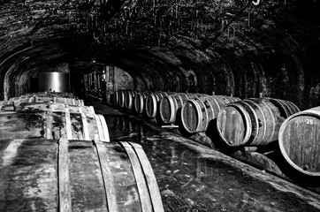 Wine barrels in an old wine cellar with red candles and fairy lights