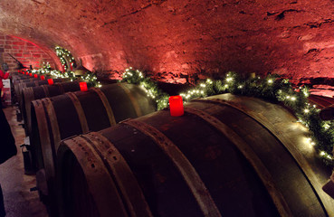 Wine barrels in an old wine cellar with red candles and fairy lights