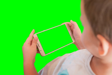 Kid watching video or play game on smart phone. Isoalted screen and background in green, chroma key.