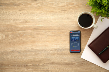 phone with app online shopping on screen and wooden table