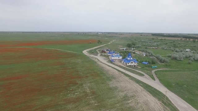 Church. Spring field. Red poppies. Video from the air. Kazakhstan.