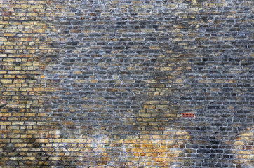 Weathered brickwall with one unusual brick. One part doesnÂ´t fit in the pattern.