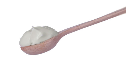 Mayonnaise in a wooden spoon on a white isolated background. white sauce. close-up.