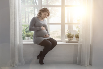 Fototapeta premium Young pregnant woman relaxing at home