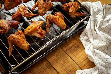 Delicious hot grilled chicken wings on grill grid with cloth.