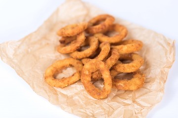Fried onion rings in paper on white background. Fast food concept