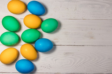 Painted Easter eggs on white wooden background