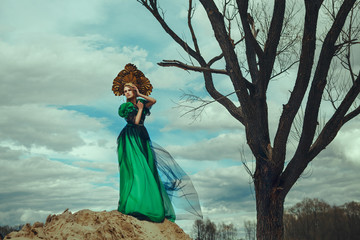 Beautiful model is posing wearing green dress and kokoshnik