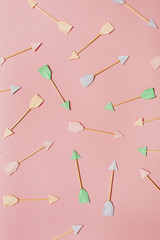 Paper Cupid arrows on pink background. Flat lay, top view Valentines Day background love concept.