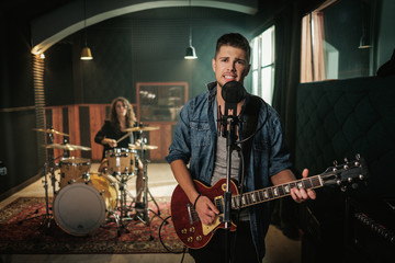 Music band having rehearsal in a studio