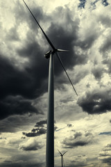 The wind generator is in dark stormy sky.