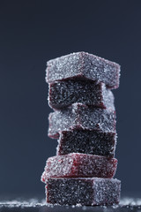 Сlose up dark shade marmalade, which is laid out by a tower. Marmalade powdered with sugar powder.