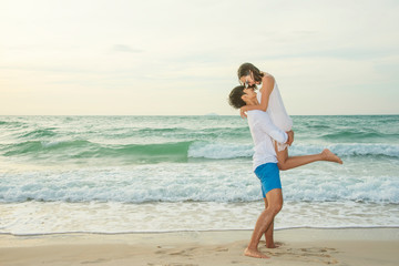 Romantic scene of couple lover on the beach at sunset. Love, wedding and valentine concept.