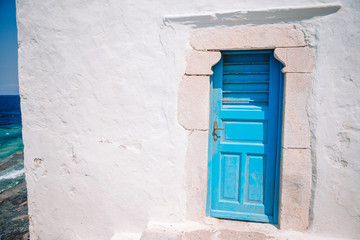 Obraz na płótnie Canvas Traditional houses withe blue doors in the narrow streets of Mykonos, Greece.