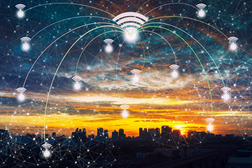 Wifi icons with lines connection symbol in the sky over the modern business city center at sunset with beautiful sky. Wireless network connection technology concept.