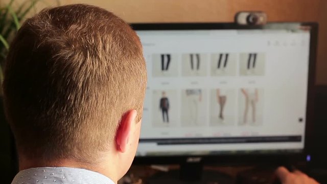 Online shopping. A man buys clothes in an online store. Blurred computer screen