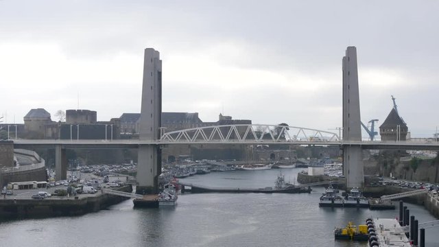 The Pont de Recouvrance is a vertical-lift bridge in Brest, France, across the river Penfeld.  It links the bottom of the rue de Siam to the quartier de Recouvrance. Cloudy weather.