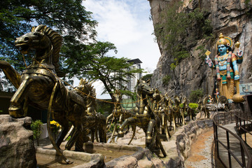 Fototapeta na wymiar Ramayana Cave at Batu Cave Complex - bronze horses pull a chariot containing the Hindu God Vishnu, Gombek, Selangor, Malaysia.