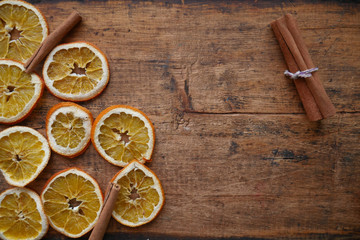 Obraz na płótnie Canvas dry orange and cinnamon slices on wooden background