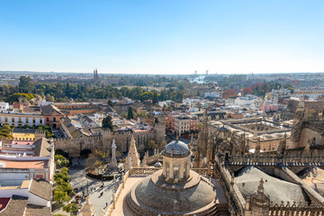 Fototapeta premium Aerial view of Seville city and Cathedral of Saint Mary of the See in Seville as seen from seen from the Giralda tower. With Royal Alcázar of Seville and The Plaza de España 