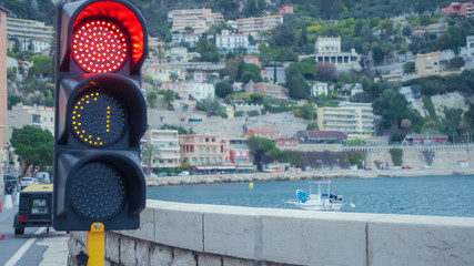 Stop red signal  at a traffic light. Mediterranean city view.  Boat along shore. Area close to the...