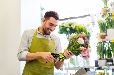 people, business, sale and floristry concept - happy smiling florist man making bunch at flower shop - obrazy, fototapety, plakaty