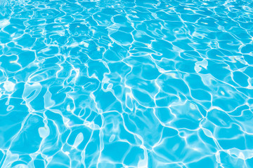 Blue and bright water surface and ripple wave with sun reflection in swimming pool