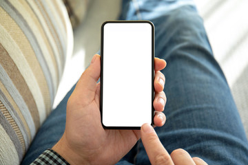 male hands holding phone with isolated screen on the sofa