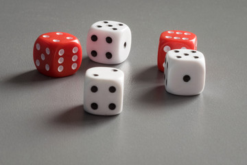 Red and white dice on a dark grey background