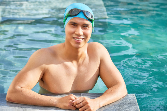 Attractive young Vietnamese man wearing rubber and goggles when swimming in pool