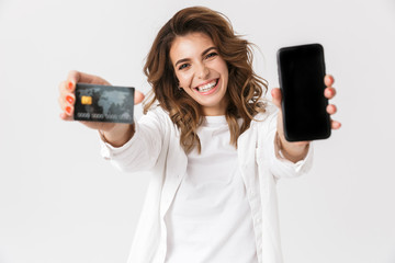 Happy young woman showing plastic credit card