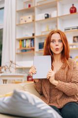 Woman holding up the tablet and whistling