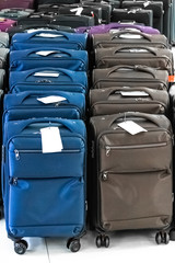 Fototapeta premium A set of suitcases with labels are arranged in a row in the large hall of the shopping center and are ready for sale.