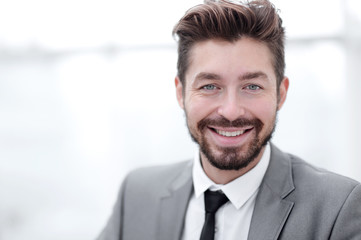 Happy young man in suit looking at camera with toothy smile