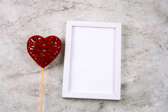 top view white mock up wooden frame and three red hearts on a marble background