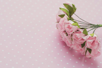 Polka dot background. Pink decorative flowers. Close-up. Place for text