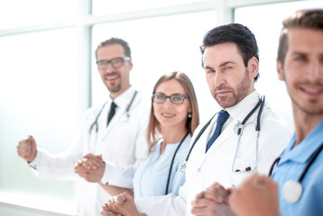 Doctors and nurses hold hands.