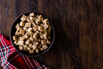 Obraz na płótnie Canvas Raw Organic Brown Sugar Cubes in Wooden Bowl Ready to Eat.