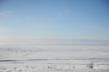 Fototapeta na wymiar Winter snow landscape. Endless space of a frozen river