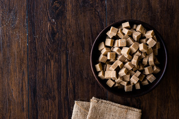 Raw Organic Brown Sugar Cubes in Wooden Bowl Ready to Eat.