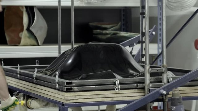 Thermoforming machine. The worker makes the form or part for the robot