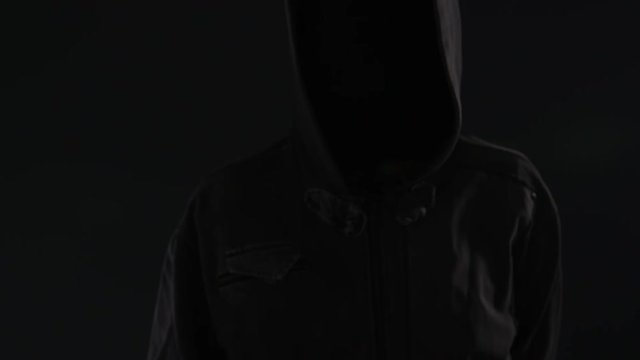 Hooded computer hacker click virtual screen, low key slow motion footage for text or graphics mock up